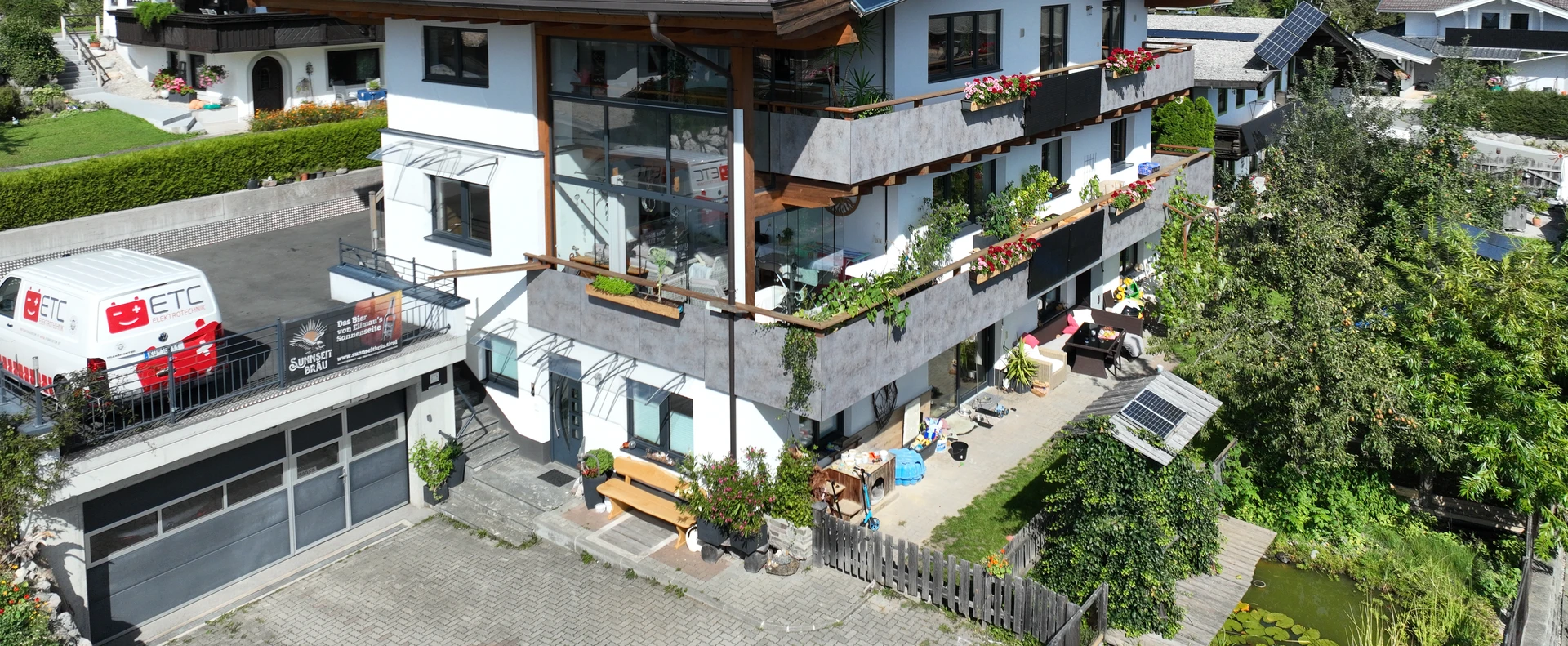 Drohnenaufnahme des FALKENSITZ Apartment mit Sunnseit Bräu Brauerei-Schild im Vordergrund — Haus und Brauerei am selben Standort